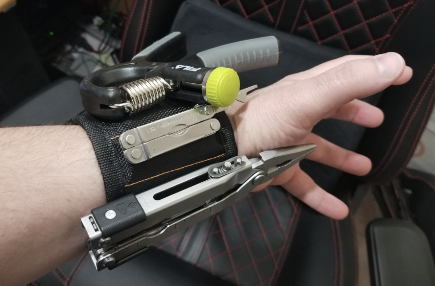 reviewer wearing magnetic wristband with various tools on it