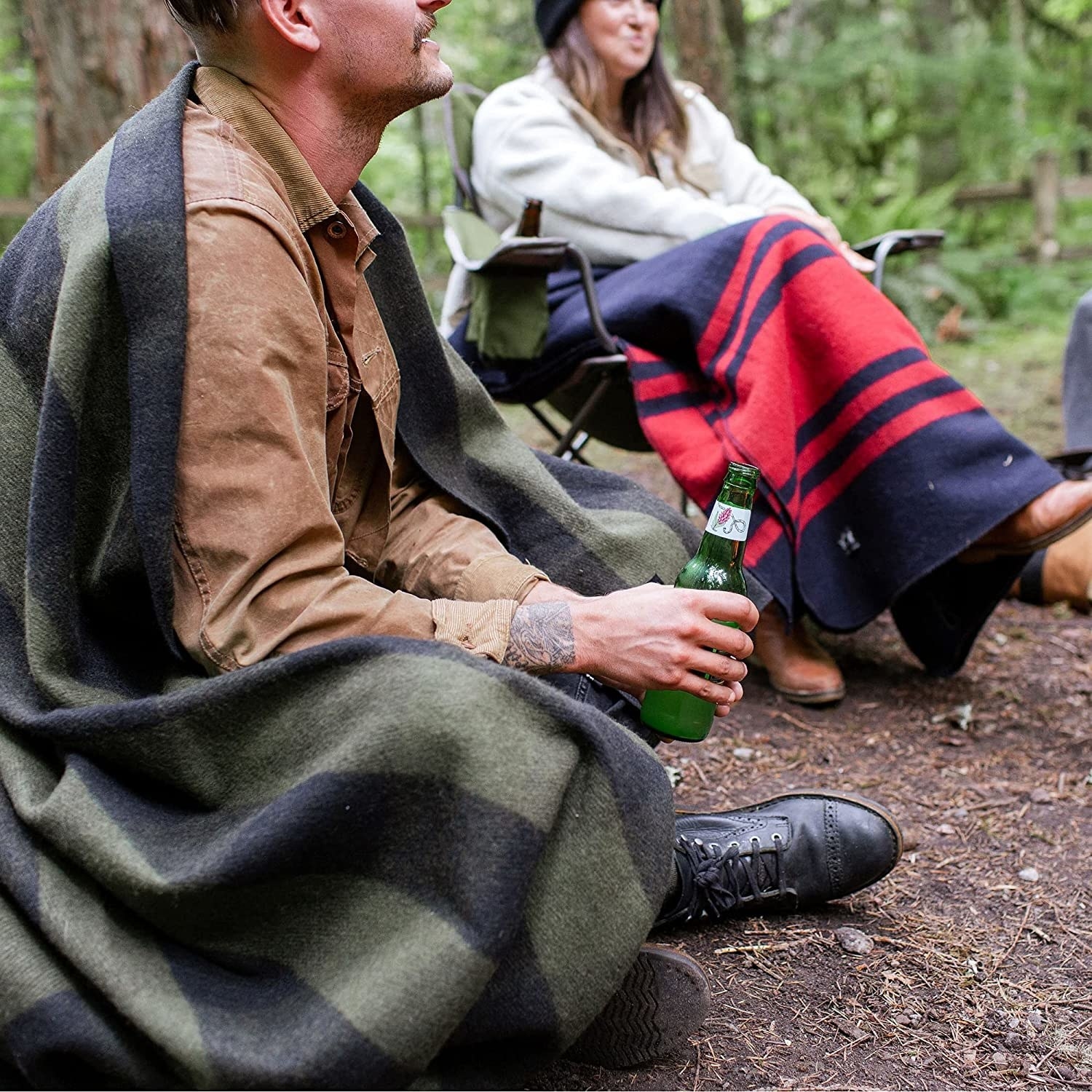two people wearing the blankets while camping