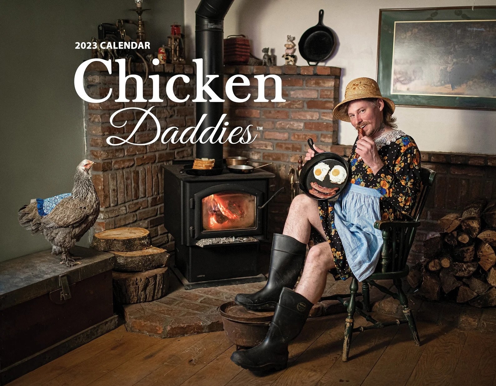front of calendar with a chicken daddy in a dress beside a chicken in a matching outfit. both are sitting by a fire.