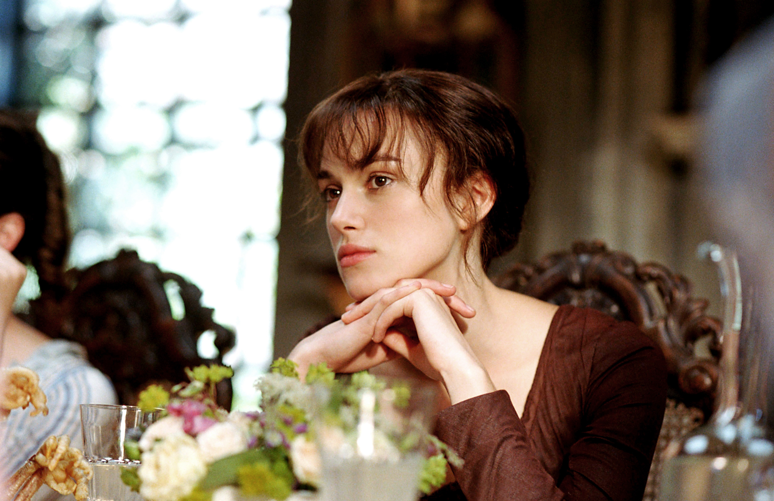 Keira Knightley sitting at a table.