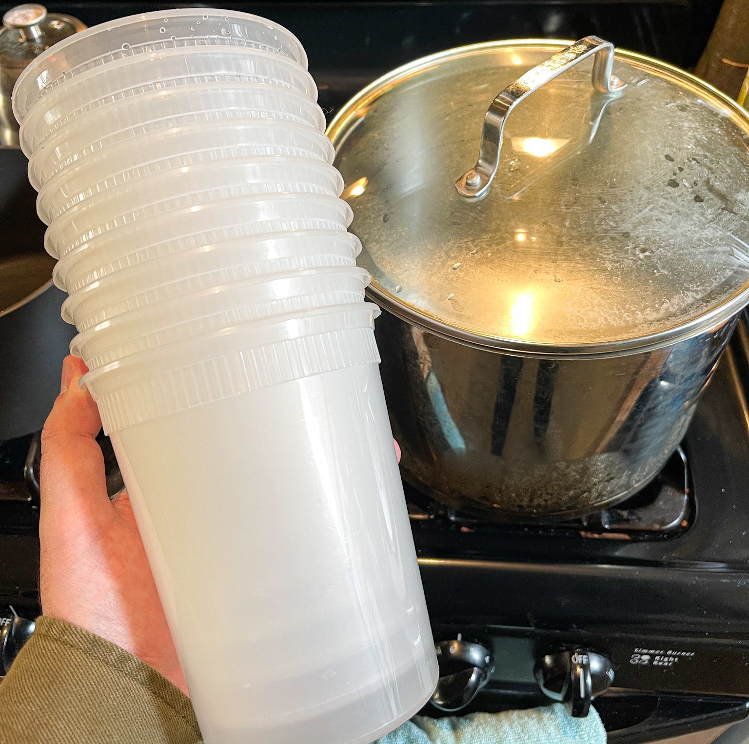 stacked deli containers in front of boiling pot of water