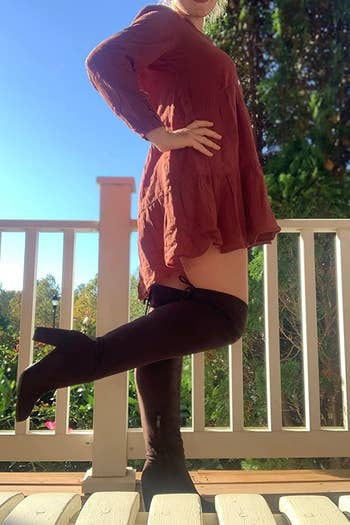 reviewer wearing brown boots with red dress