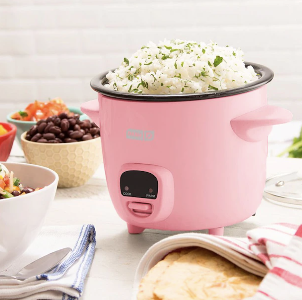the rice cooker on a counter surrounded by food