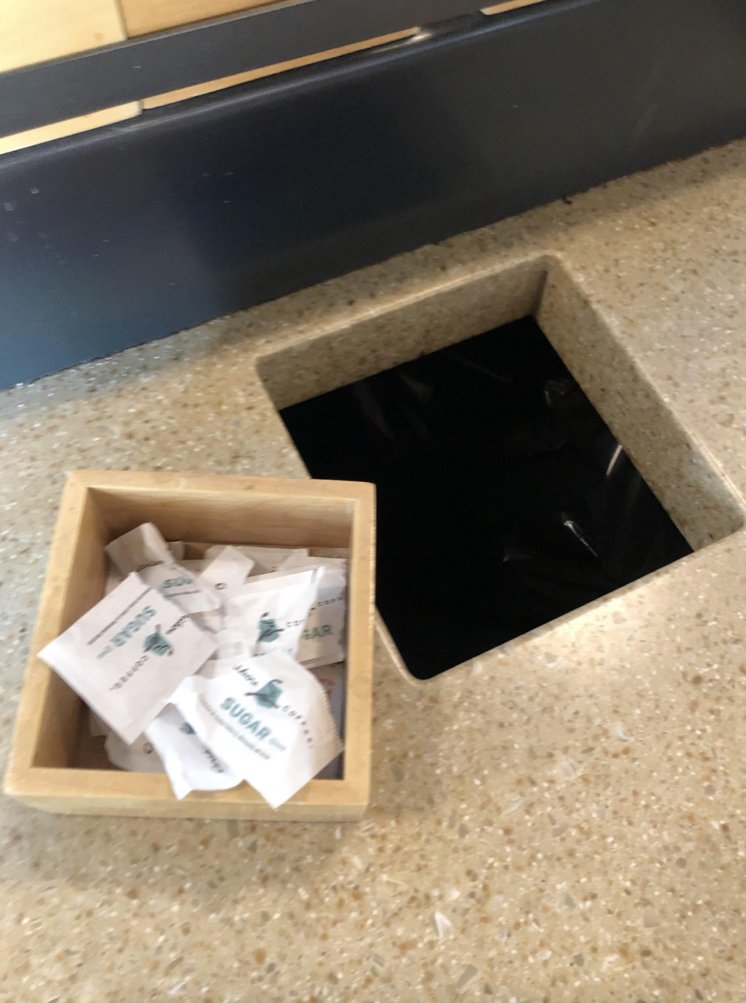 A napkin holder filled with empty sugar packets