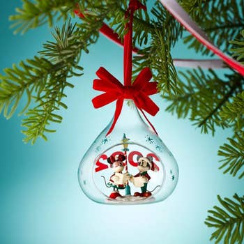 The Mickey and Minnie ornament hanging from a tree