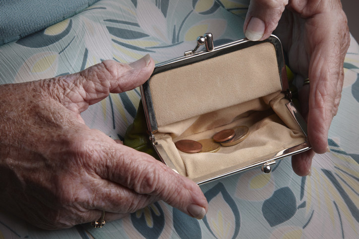 A person holding a coin purse open with a little bit of change inside