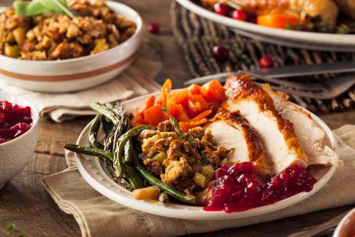 A delicious Thanksgiving feast comprised of green beans, yams, cranberries, stuffing and carved turkey