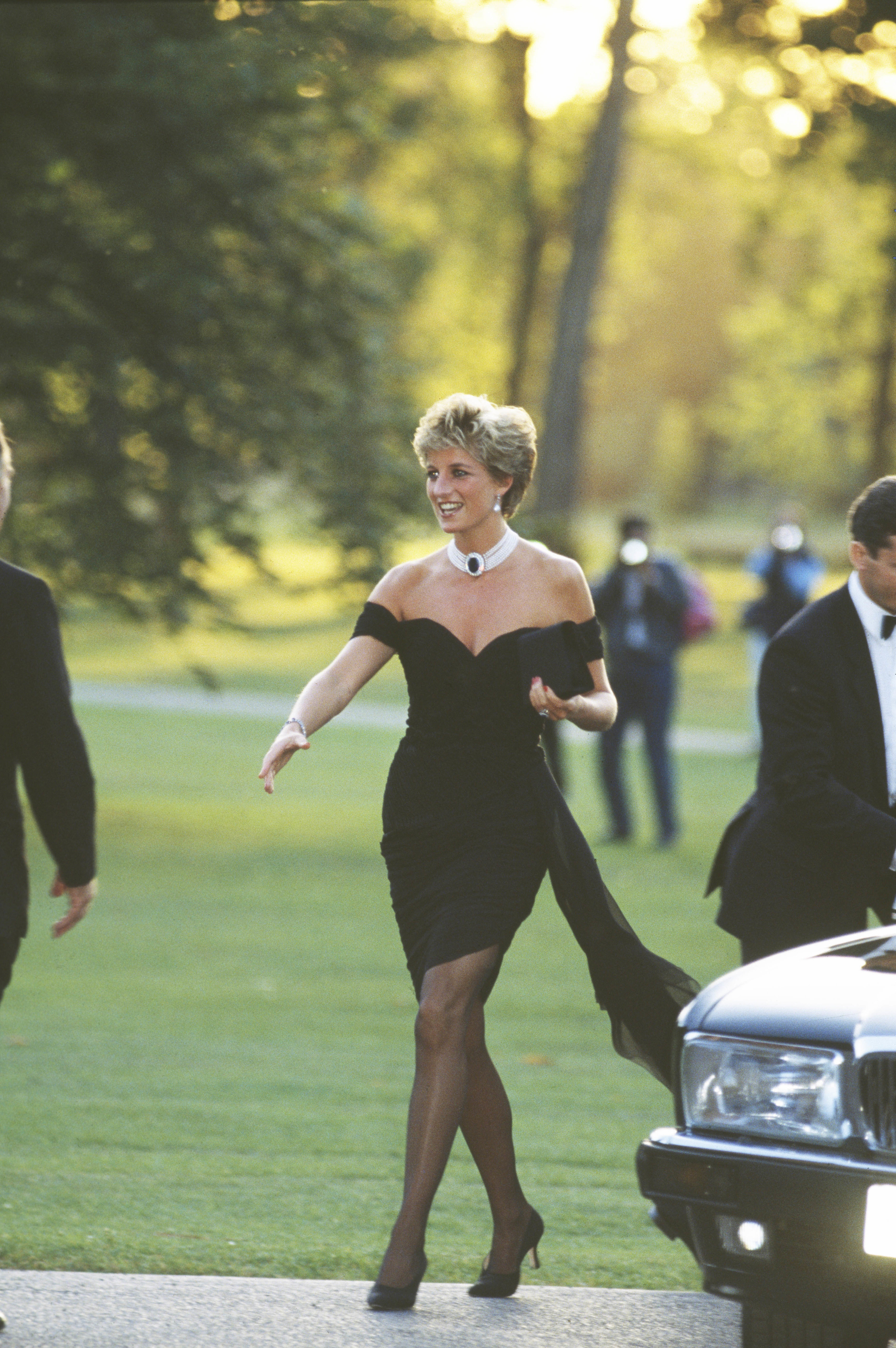 Princess Diana in the revenge dress with her arm outstretched to greet someone
