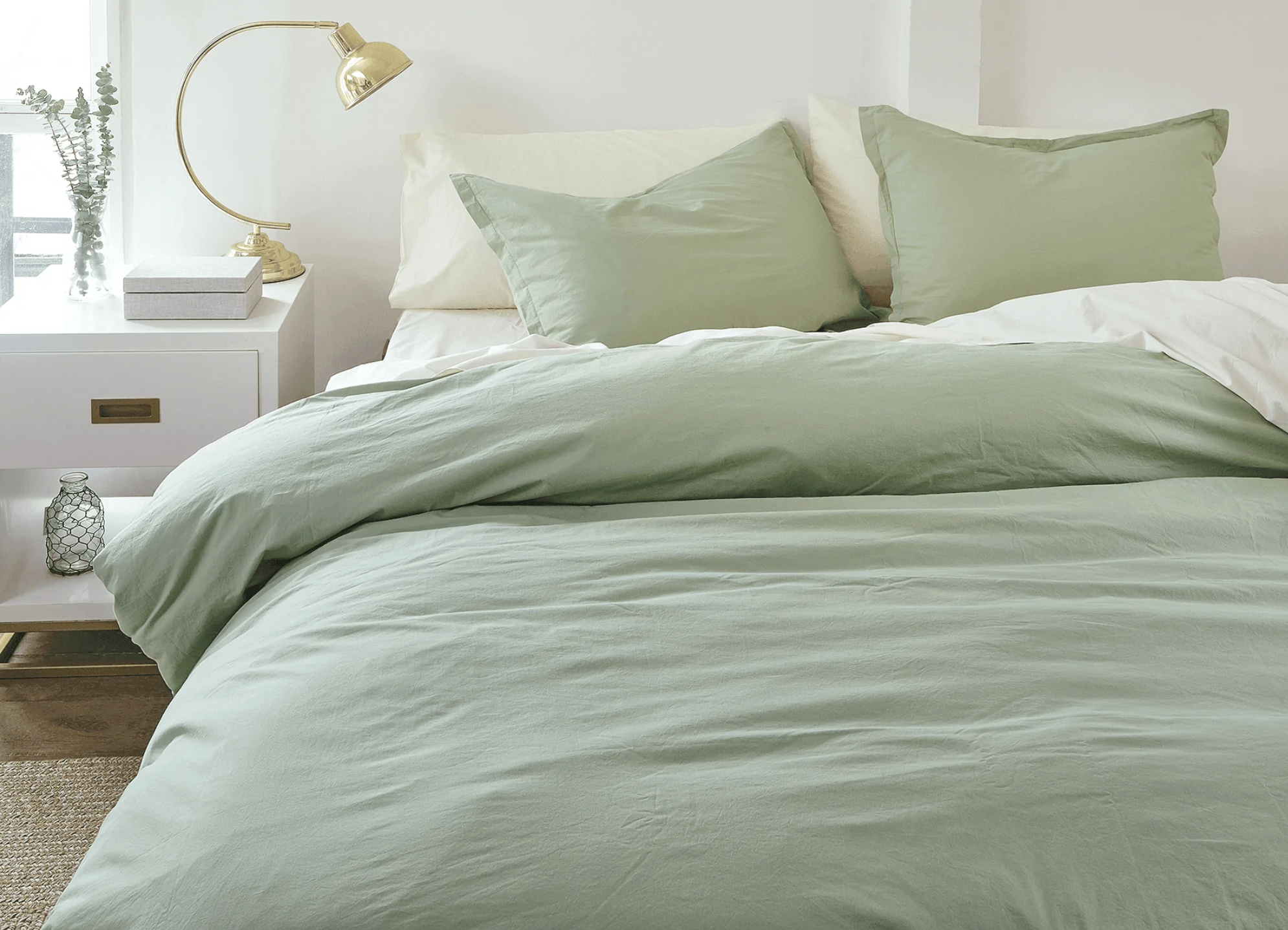 a set of percale sheets in a soft shade on a perfectly made up bed