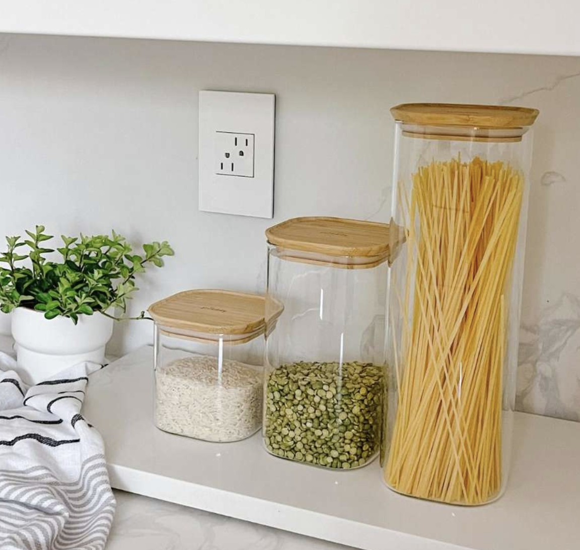 the canisters on a marble countertop with food inside of them