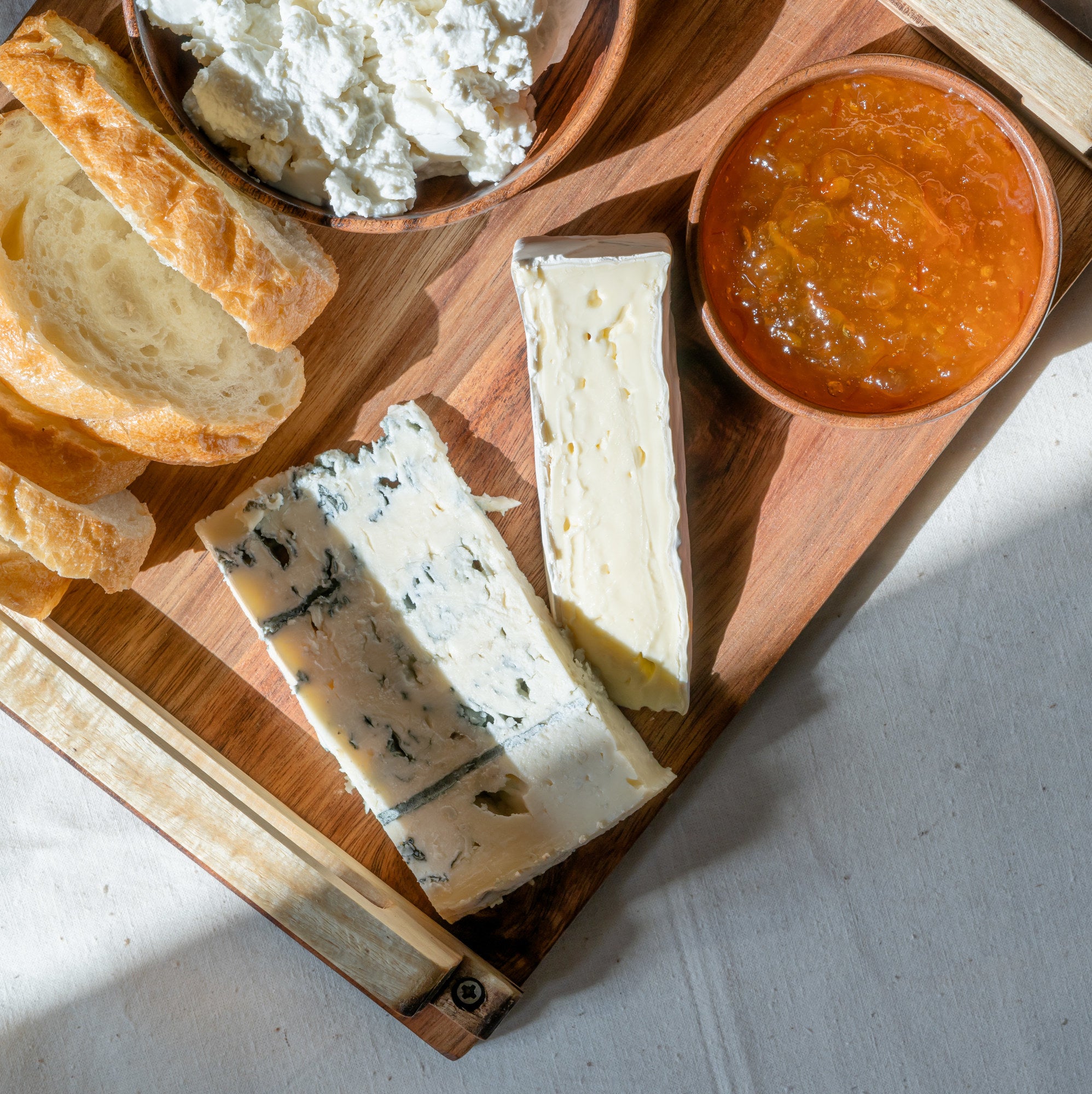 fancy cheeses arranged on a cheese board