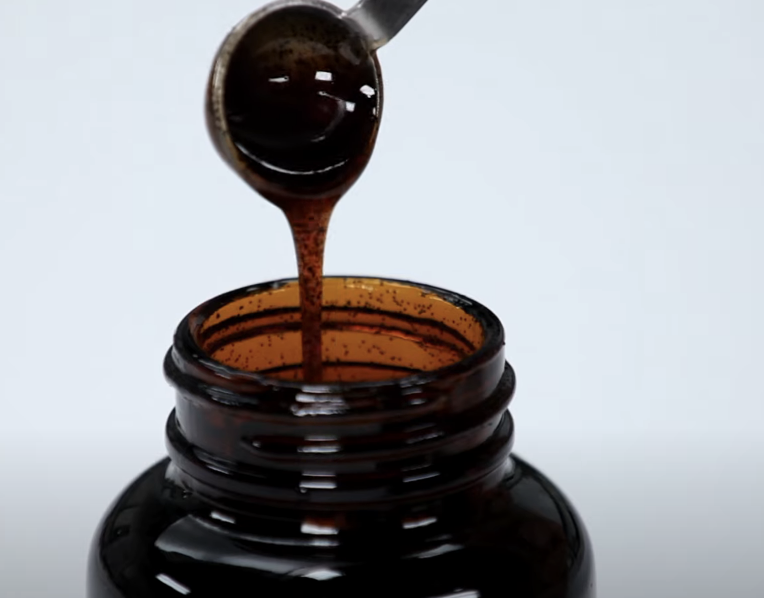 vanilla bean paste slowly pouring into an amber jar