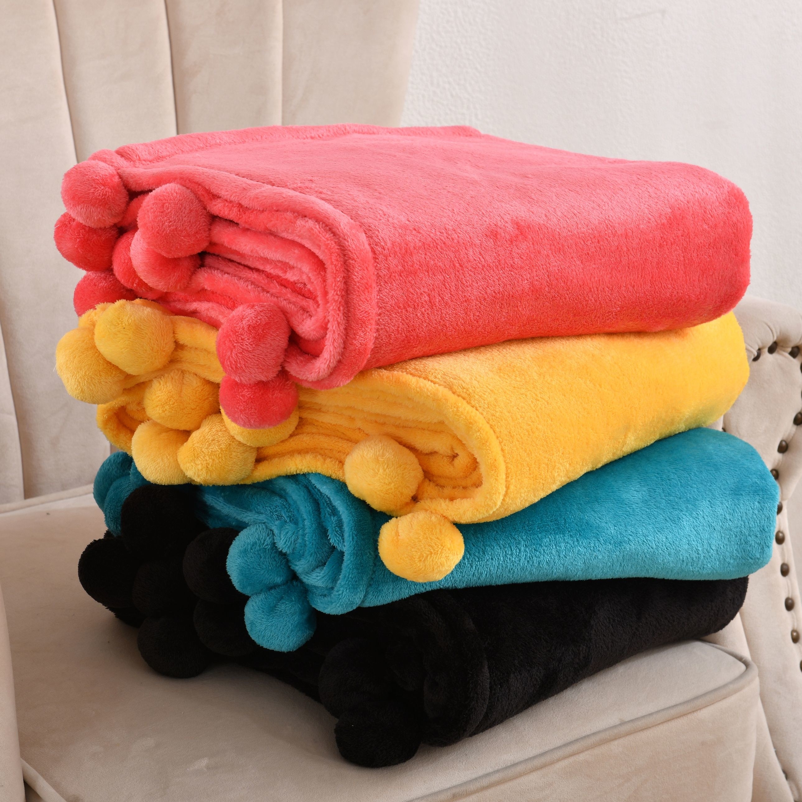 four of the blanket stacked in black, blue, yellow, pink