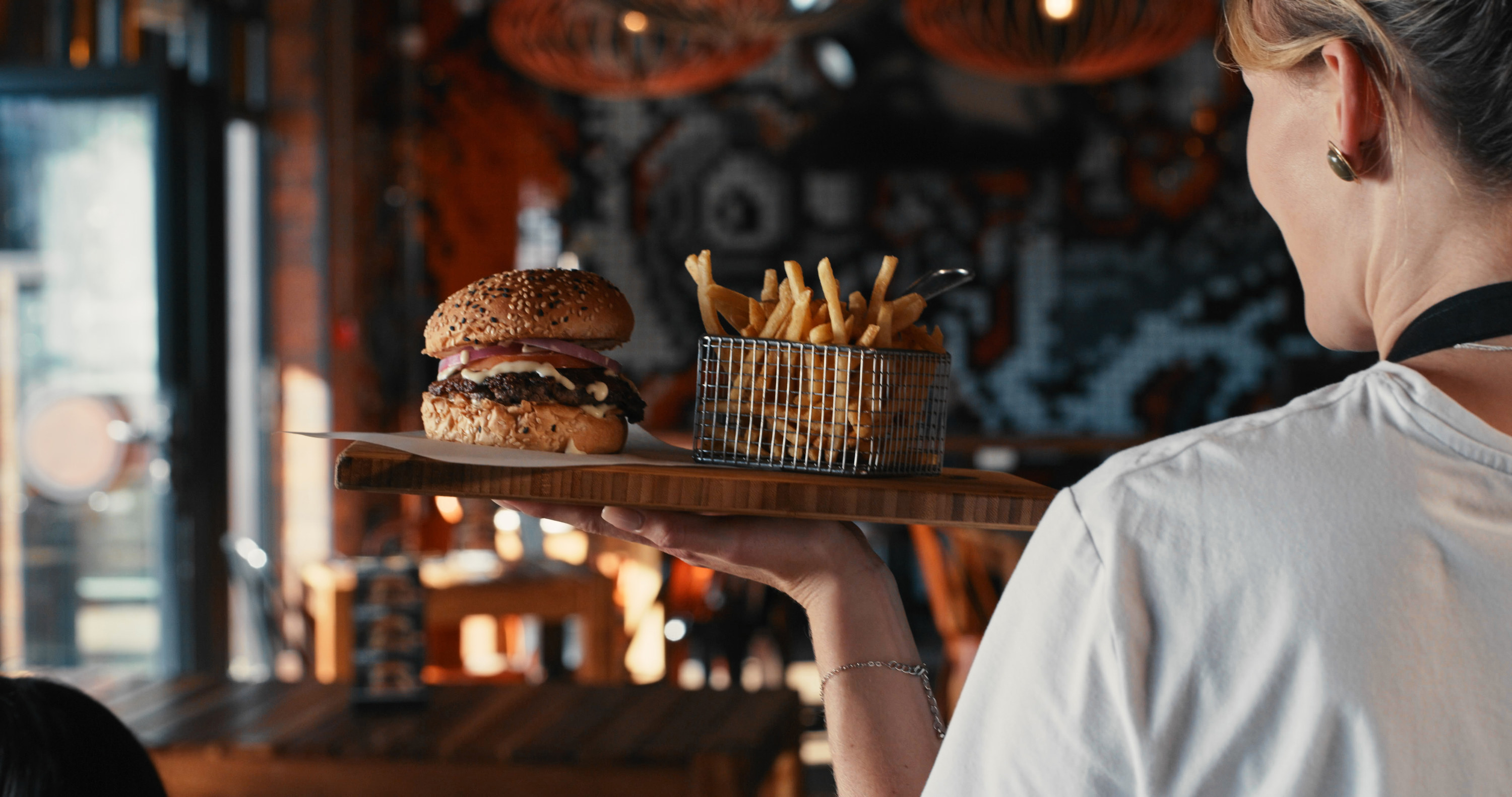a waiter holding burger and fries