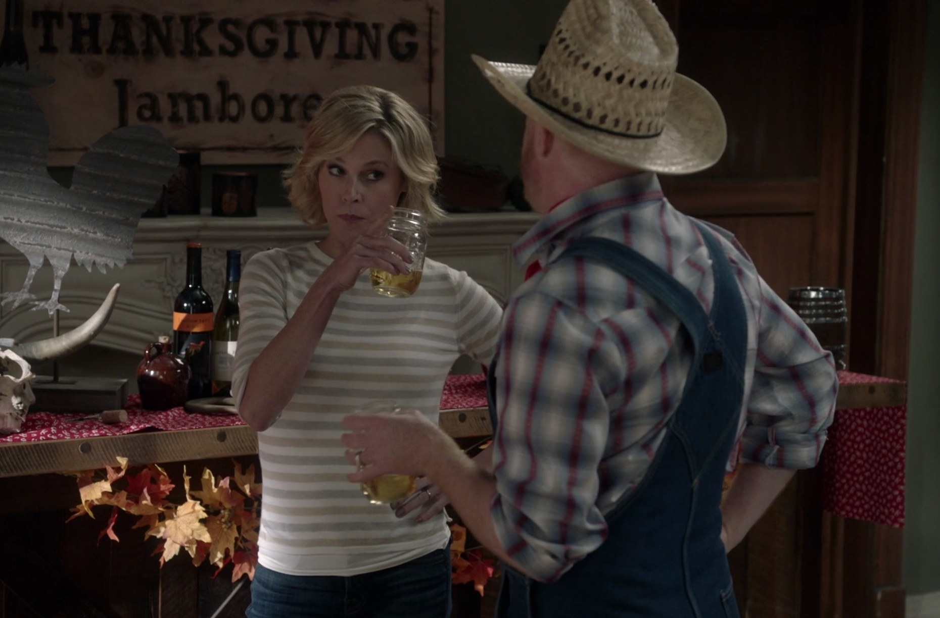Claire points her mason jar of wine at Mitchell, who&#x27;s dressed like a farm hand