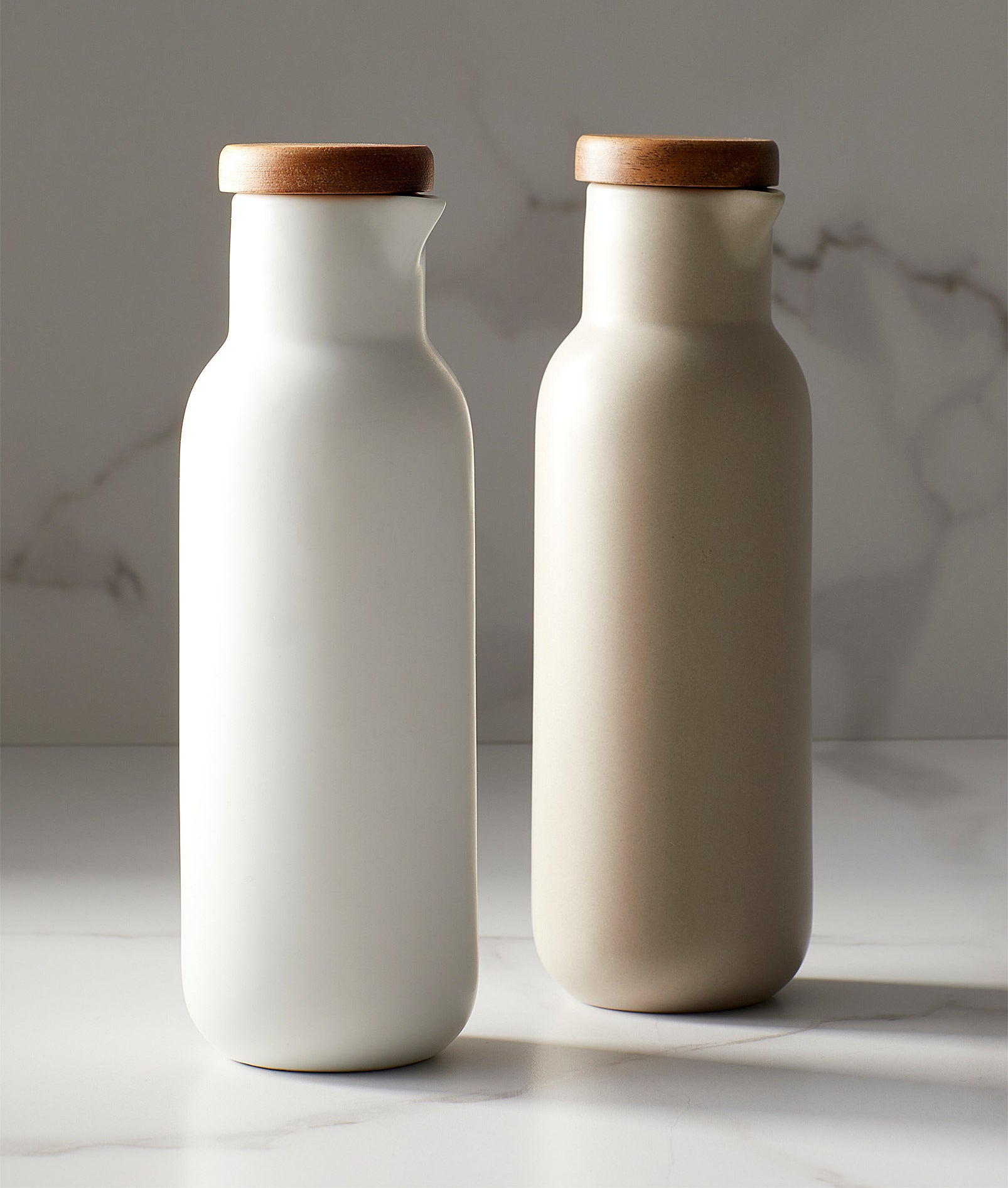 a pair of neutral porcelain cruets with acacia wood caps