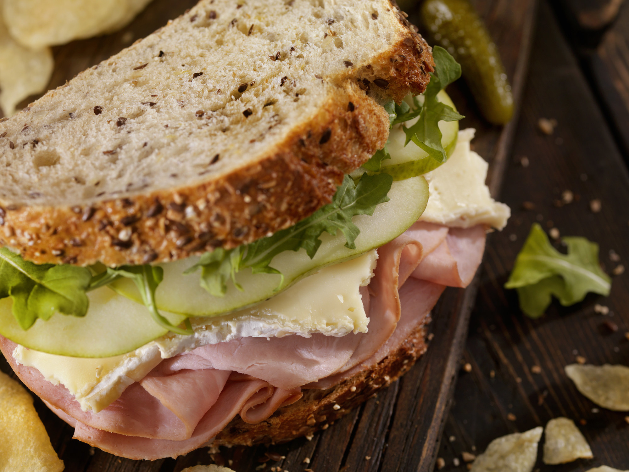 A ham sandwich with sliced green apple