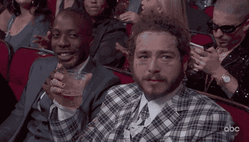 a gif of post malone drinking with an impressed face