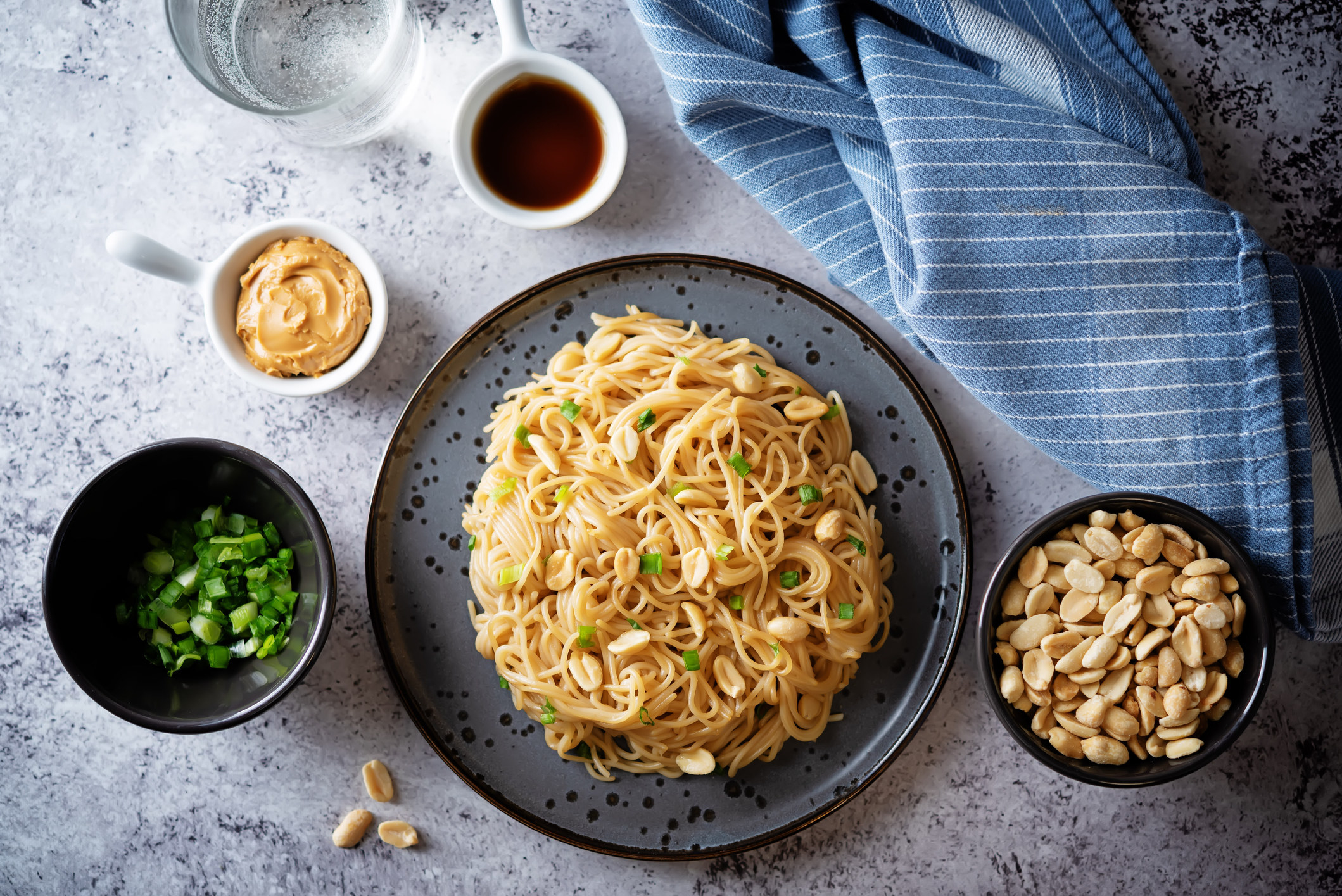 Pasta with peanut butter soy sauce, roasted peanuts, and scallion