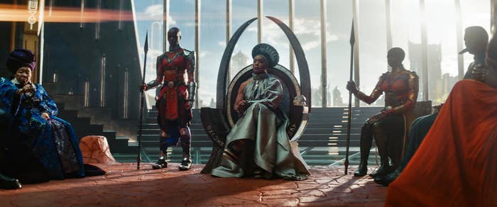 Queen Ramonda sitting with others in the throne room