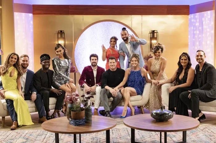The cast of season three of Love Is Blind smiles for a group photo as they sits on several couches