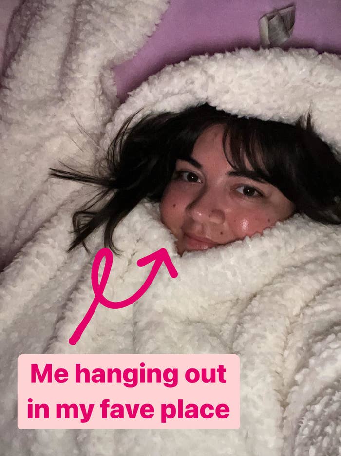 Bianca laying in her bed wearing a cozy hooded sweater