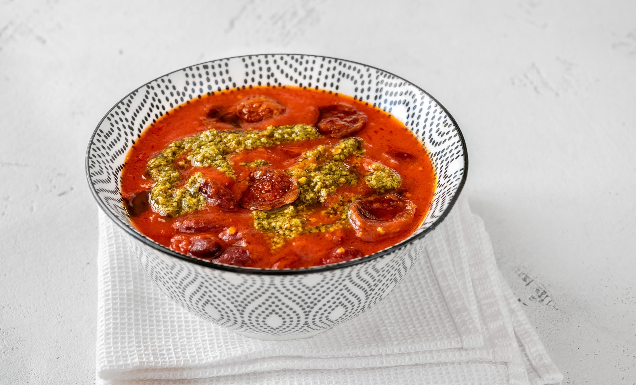 A bowl of tomato soup with pesto