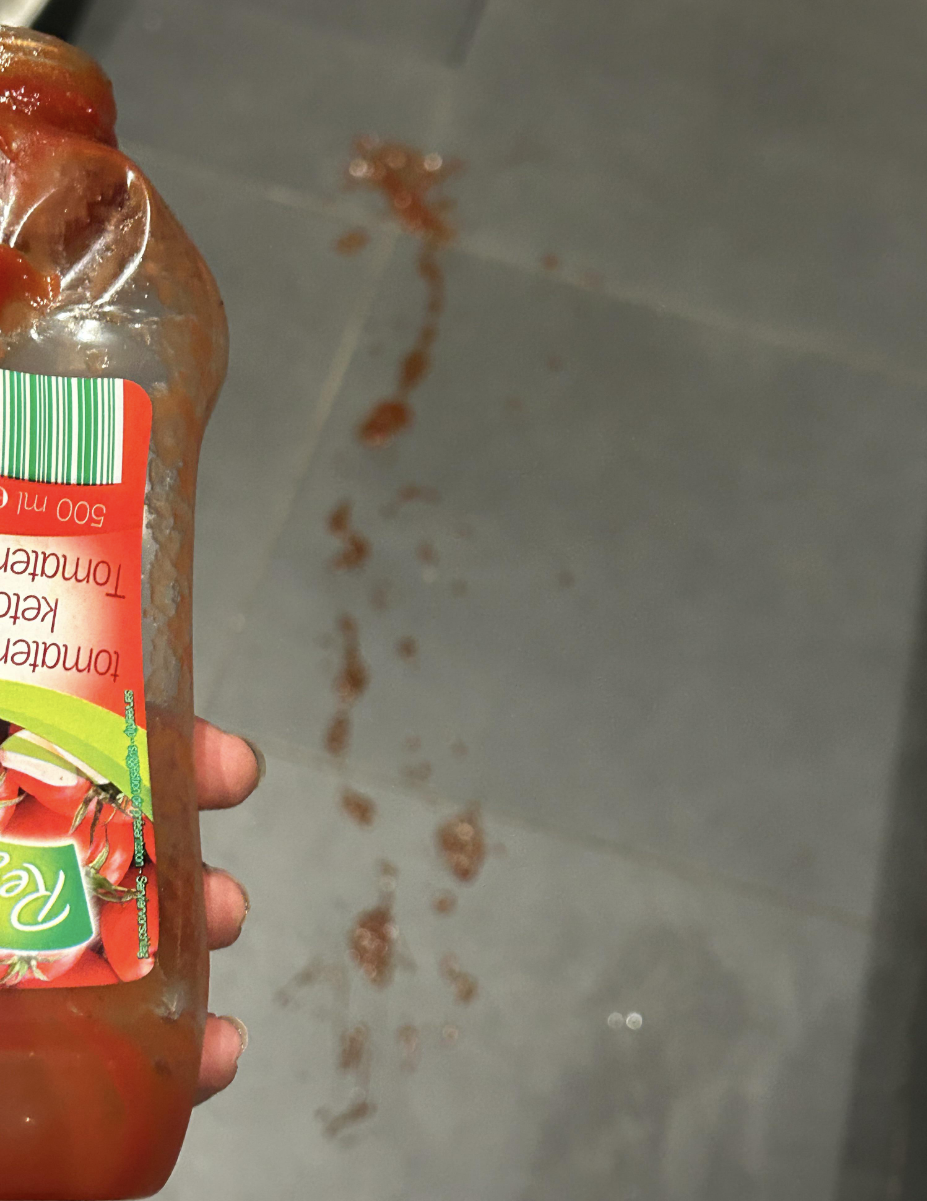 A trail of ketchup runs along a kitchen floor