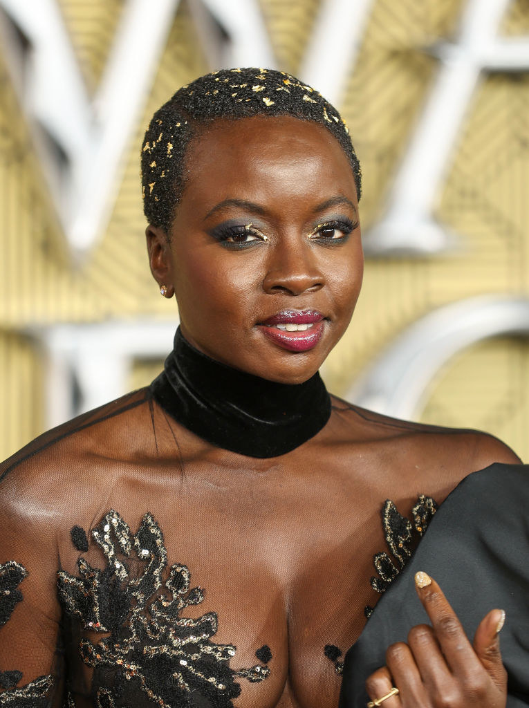Close-up of Danai in a lacy outfit with a choker neckline