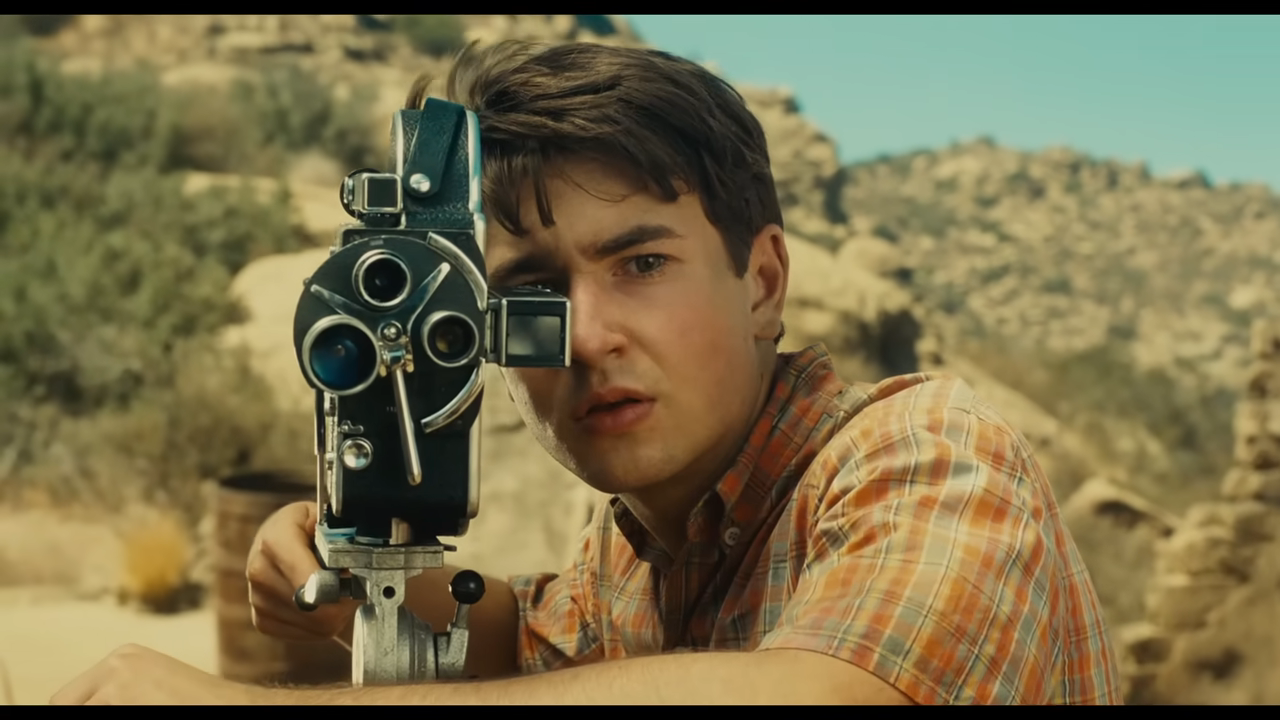 A young man behind a camera