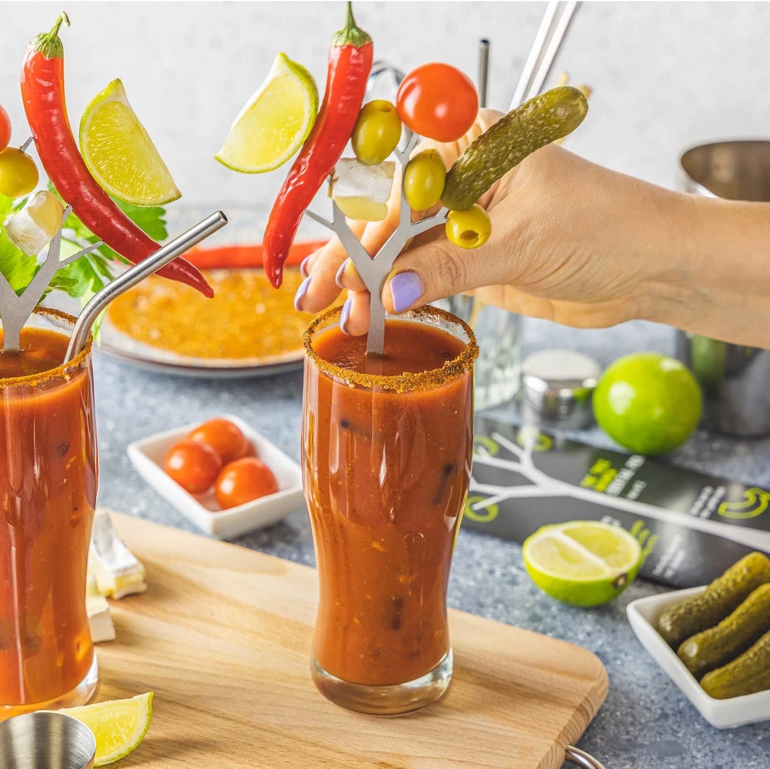 a person putting the cocktail branch swizzle stick into a bloody mary