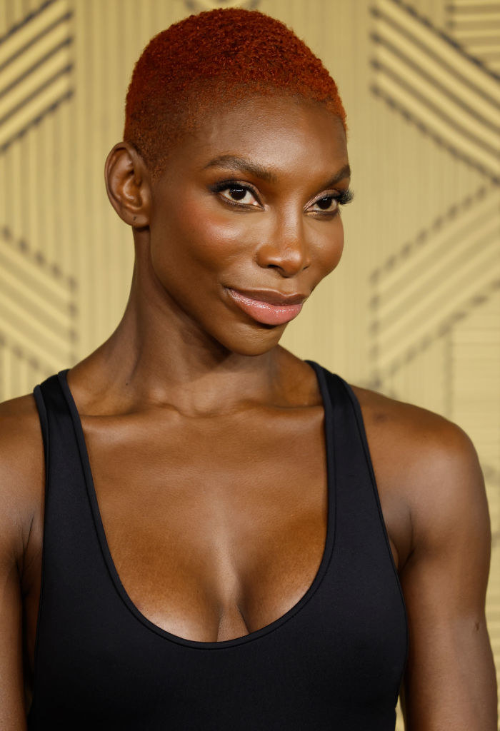 Michaela with close-cropped hair and a sleeveless top