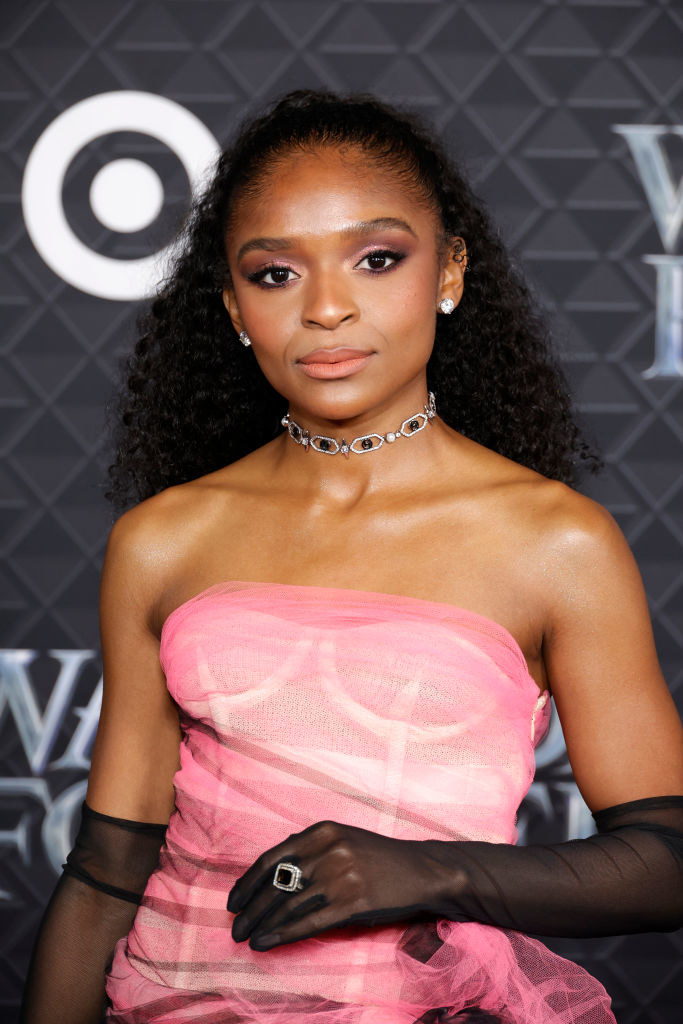 Dominique in a choker necklace, strapless outfit, and long, diaphanous gloves