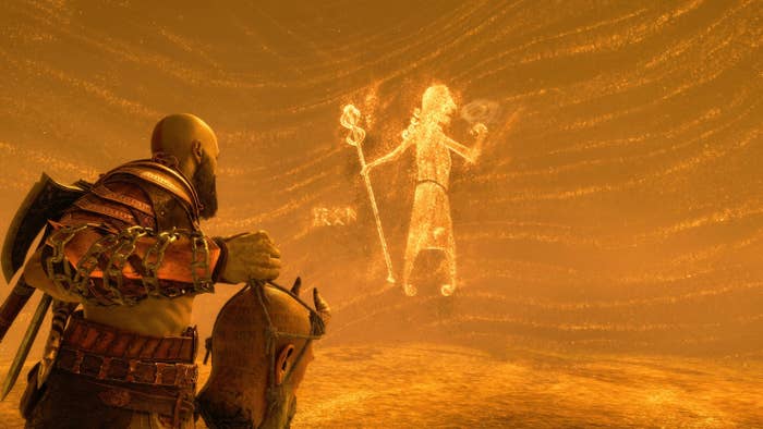 A bald man in leather armor with an ax on his back holds a disembodied head as they watch a shifting image made of sand