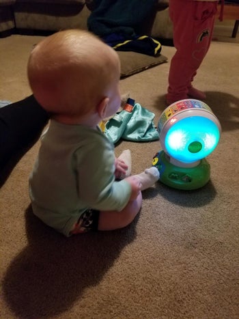 reviewer's photo of their baby playing with the toy