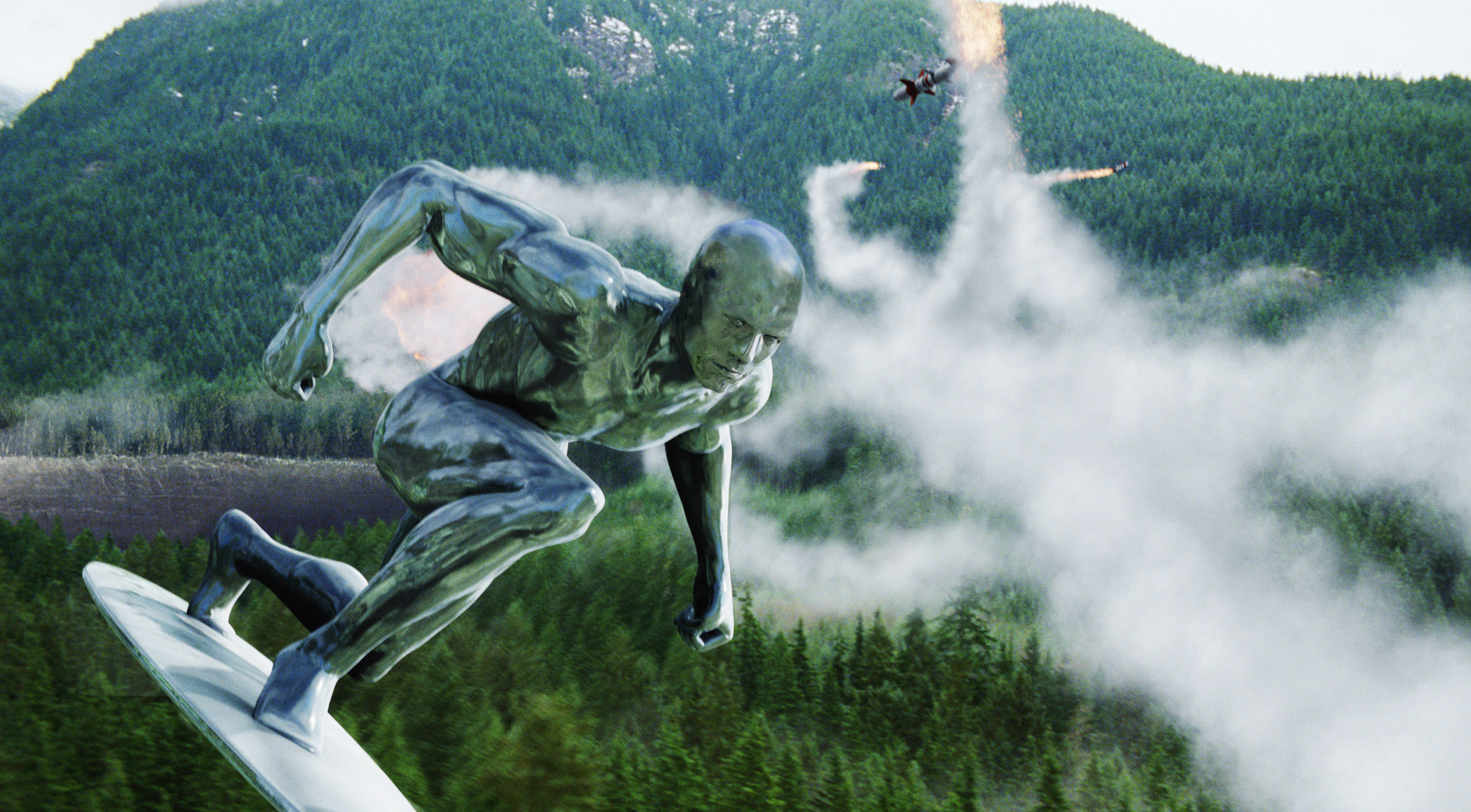 A skinny, silver extraterrestrial flies in the path of several missiles above a vast forest