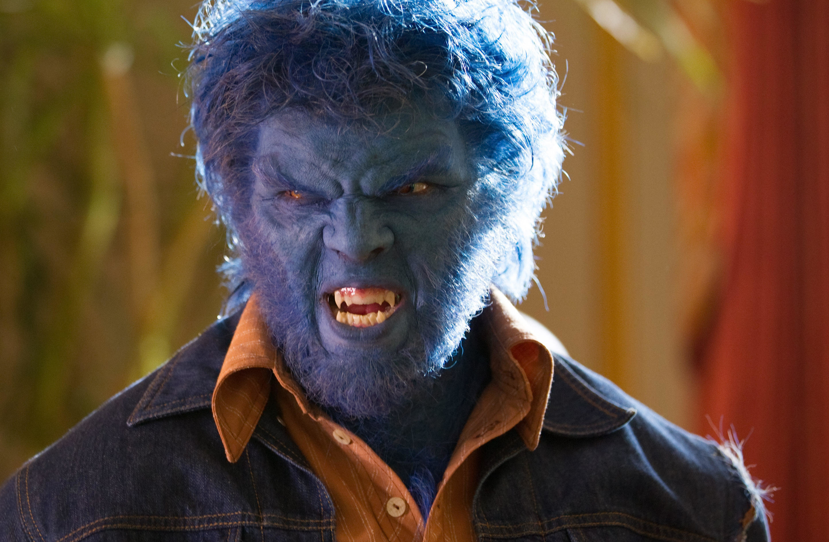 A blue-haired, blue-skinned monstrous mutant in a denim jacket snarls at the camera