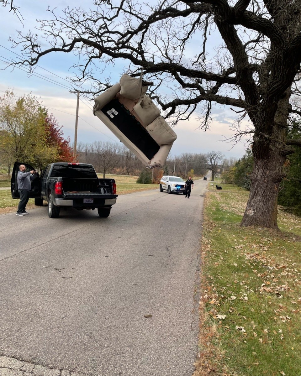 A sofa that ended up getting stuck in a tree as it was being hauled in a truck