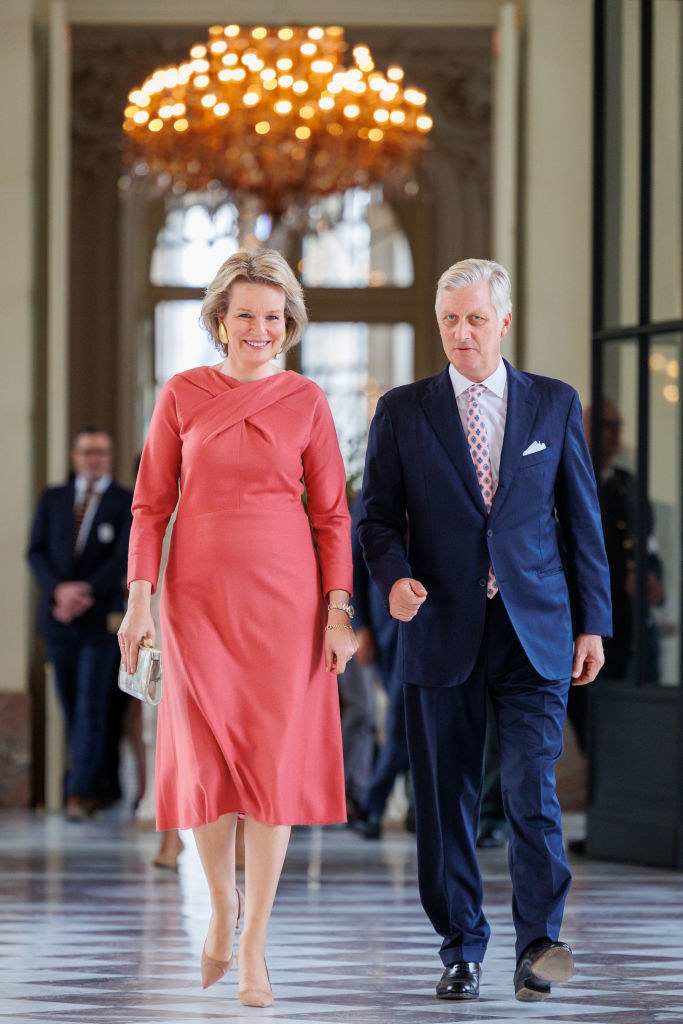 Queen Mathilde and King Philippe walking down a hallway