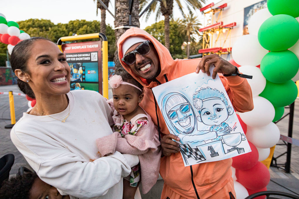 Brittany smiles as she holds Powerful next to Nick who&#x27;s holding up a sketch of him and his daughter