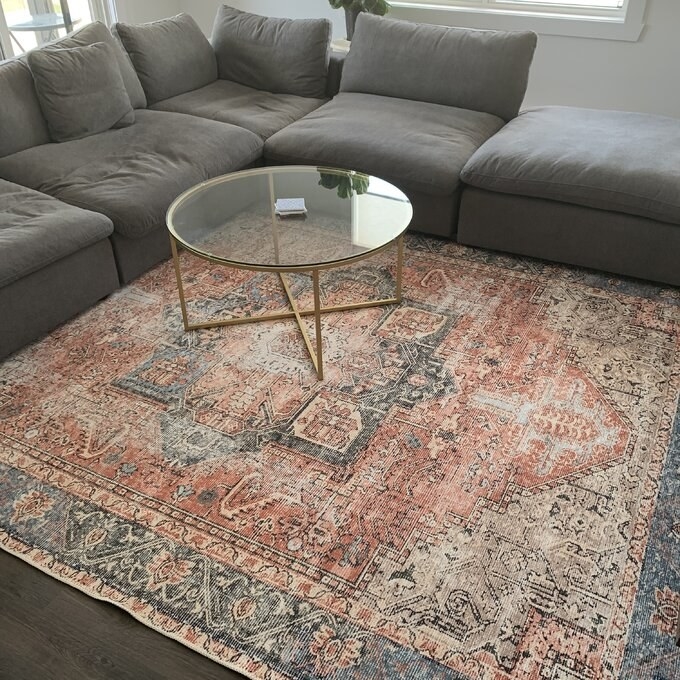reviewer photo showing the 7x10 rug in their living room with a coffee table and grey sofa