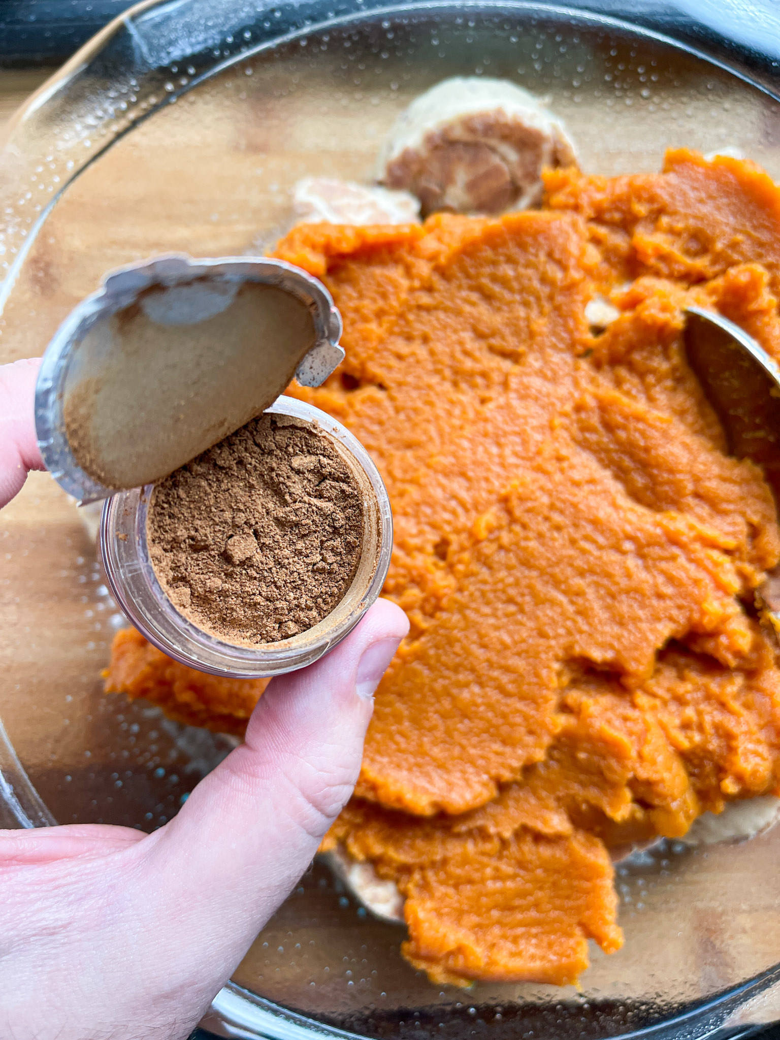 open container of pumpkin pie spice over pumpkin puree