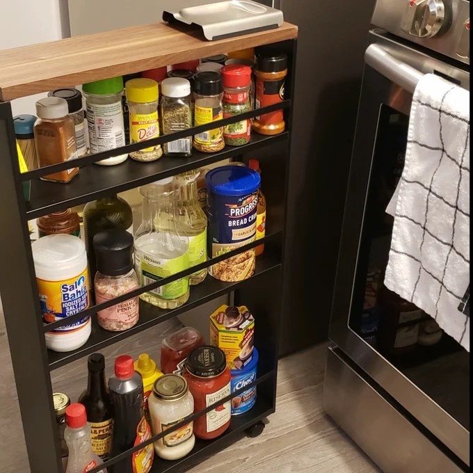Reviewer image of rolling cart filled with condiments next to stove