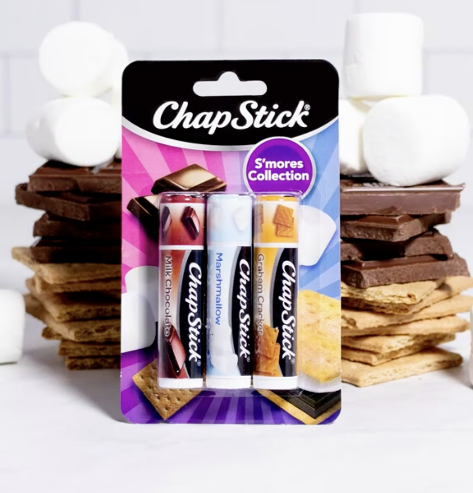 The ChapStick S&#x27;mores Collection with real s&#x27;mores in the background