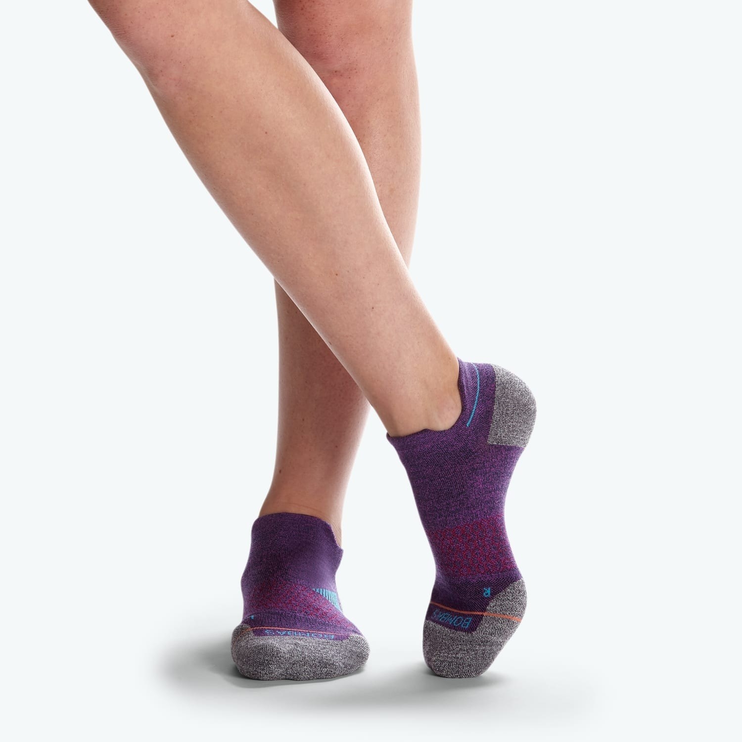 A model&#x27;s feet in purple ankle socks with grey toes and heel