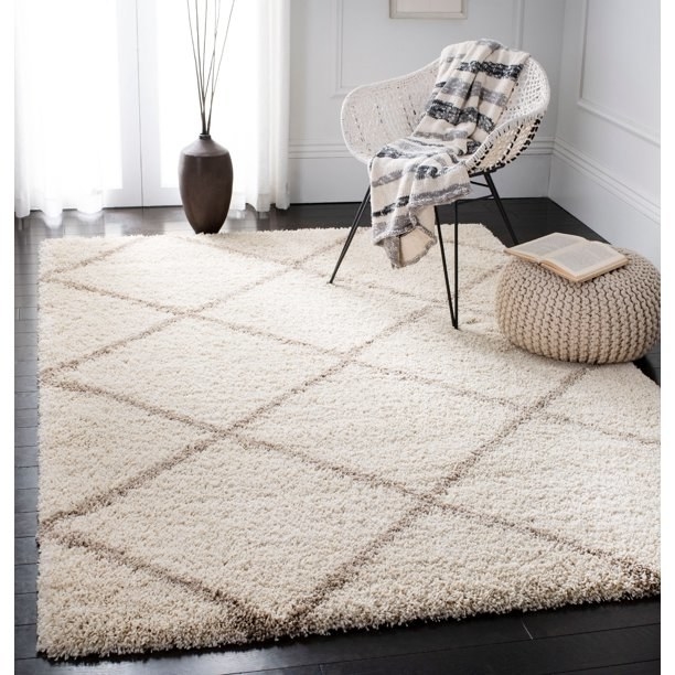 rectangle geometric-printed rug below corner chair and knitted pouf ottoman