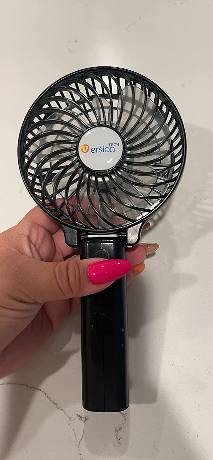 reviewer holding black portable fan
