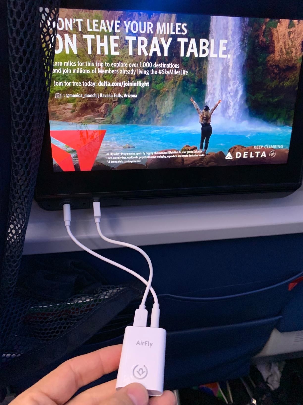 reviewer photo of AlrFly plugged into screen on the plane