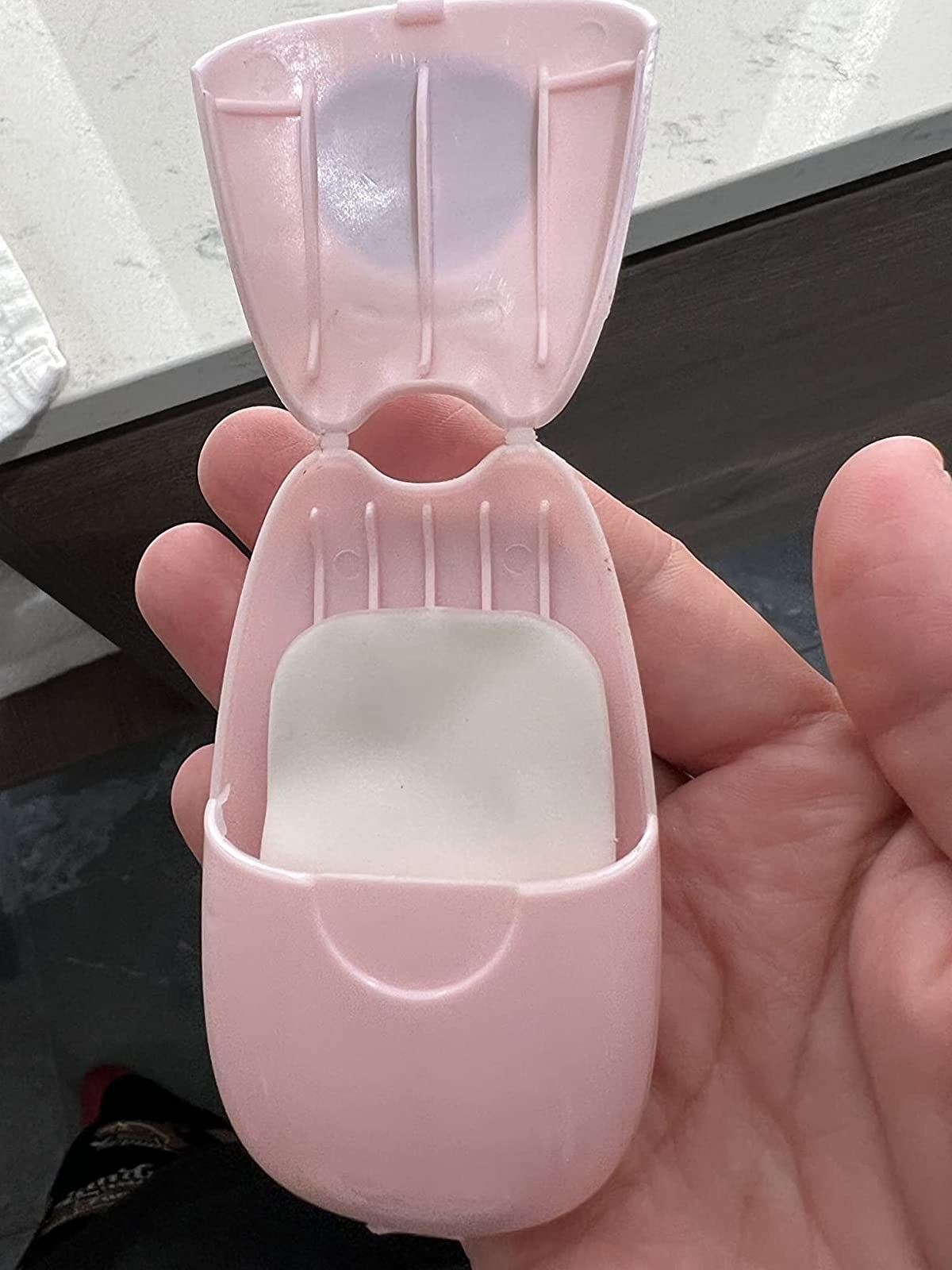 reviewer photo of small pink soap sheet dispenser