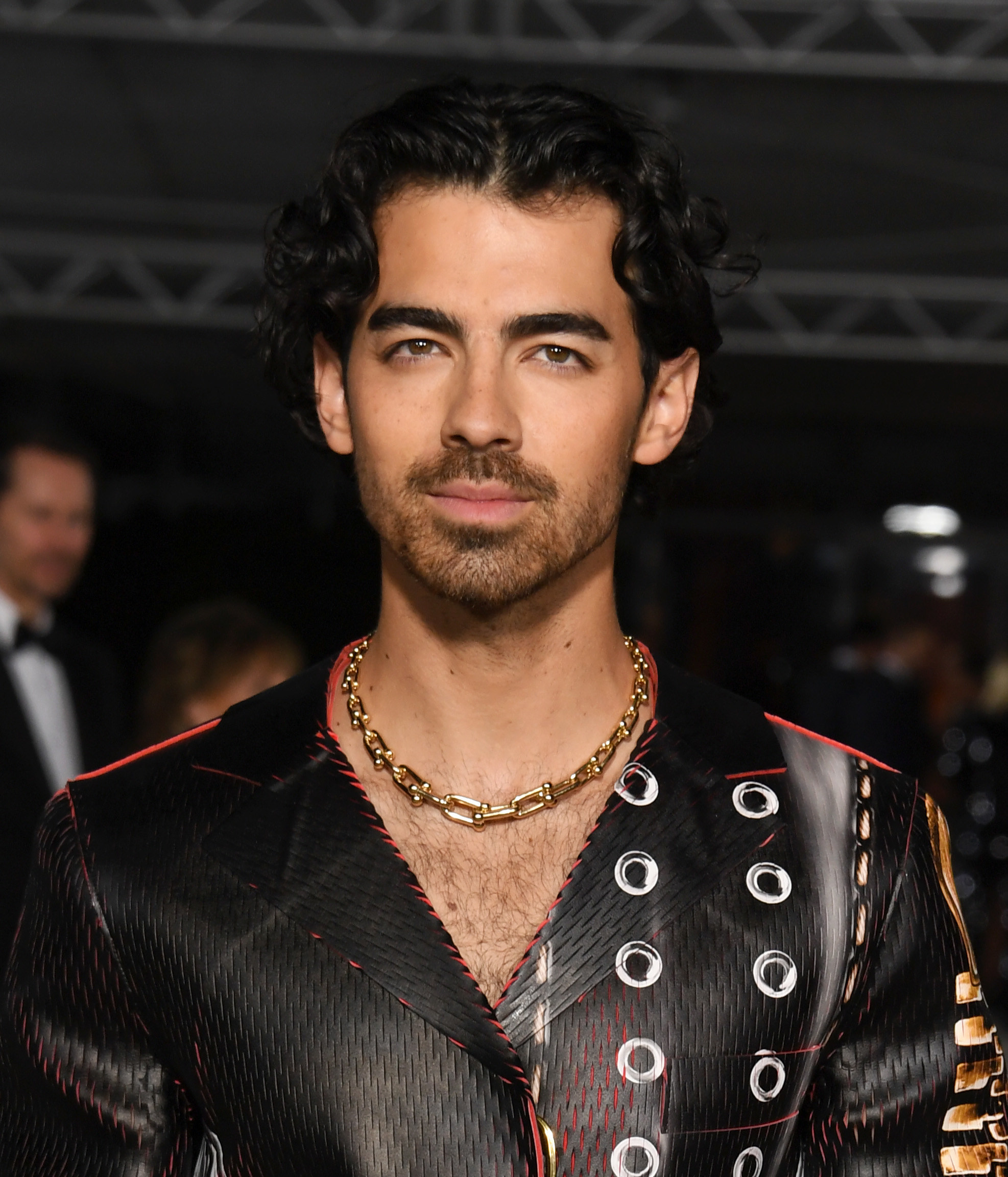 Close-up of Joe wearing a thick gold chain necklace